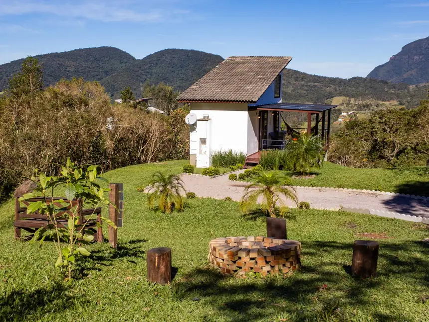 Jardim com caminho de pedras e canteiros ao redor do chalé