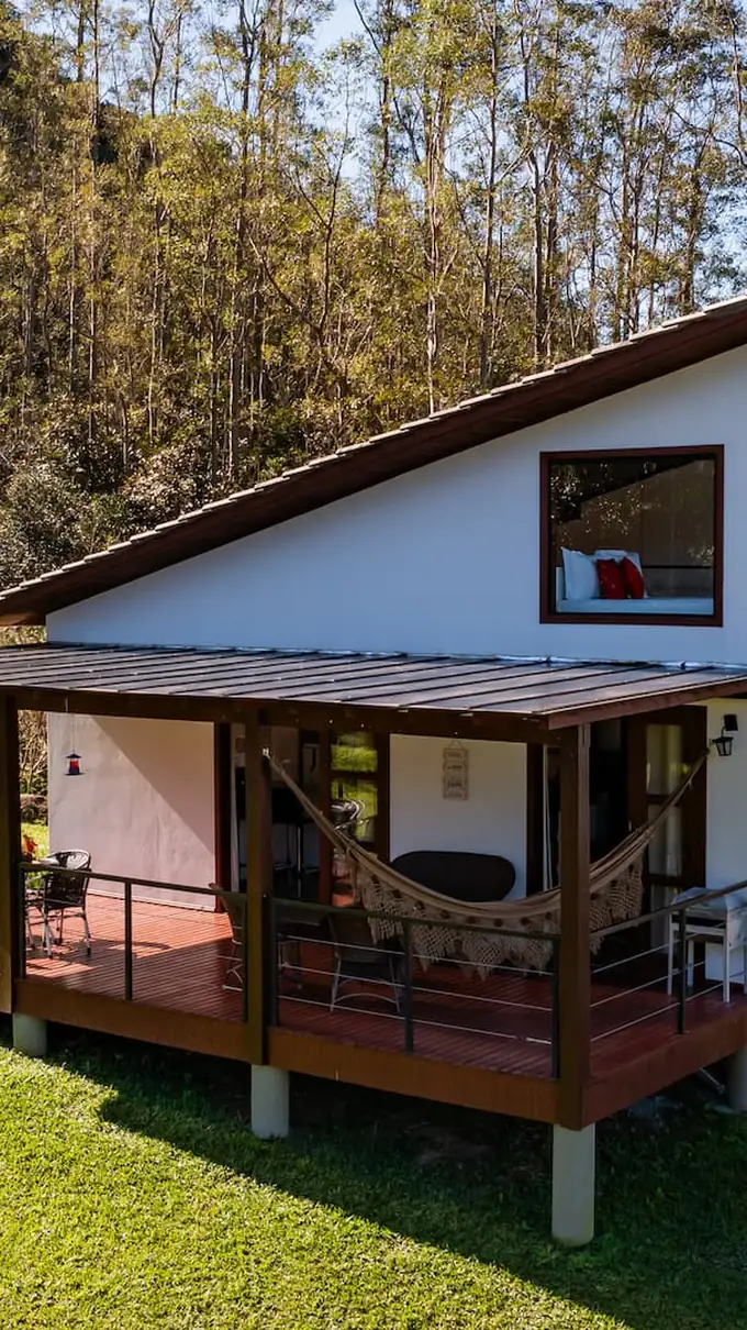 A tiny house do Chalé Casal sobre o gramado, entre as árvores