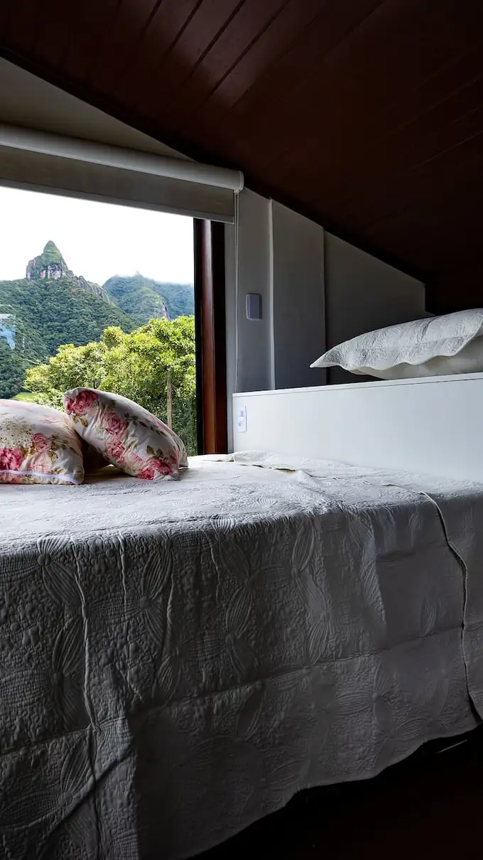 Mezanino com cama de casal sob o telhado de madeira