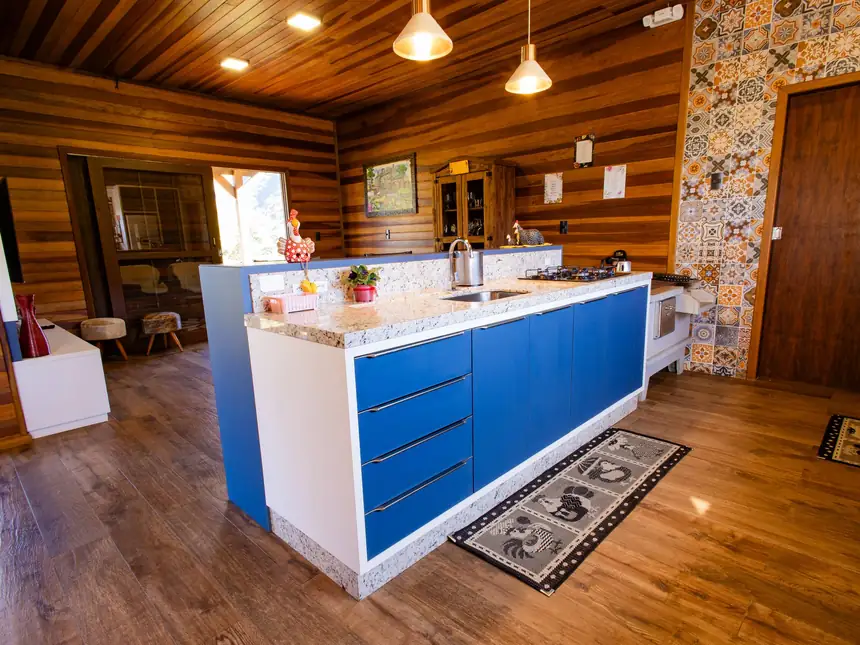 Cozinha completa com ilha azul e banquetas