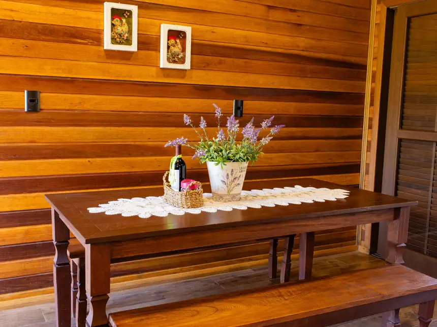 Mesa de jantar de madeira junto à parede de madeira