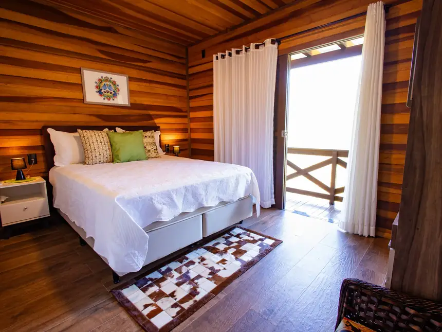 Quarto com cama queen e saída para a varanda