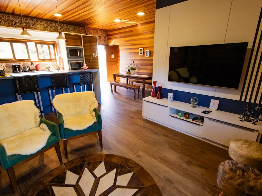 Sala de estar do Chalé Família com sofá e TV