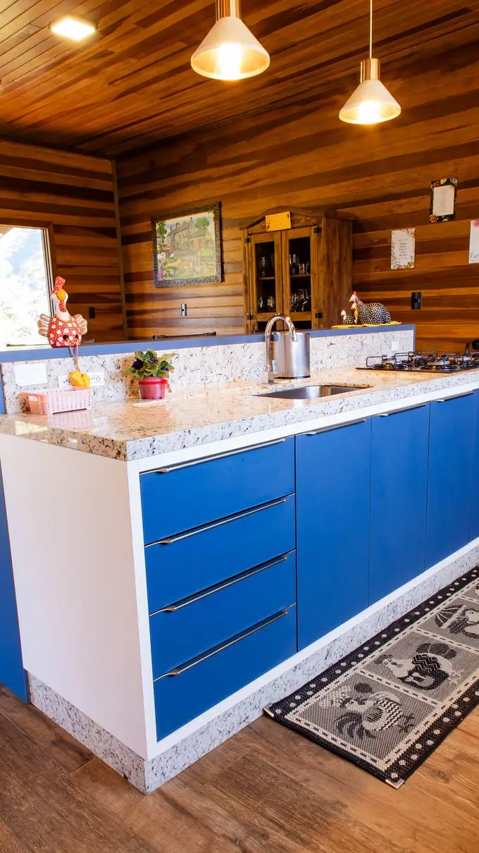 Cozinha com ilha azul, fogão e bancada de madeira