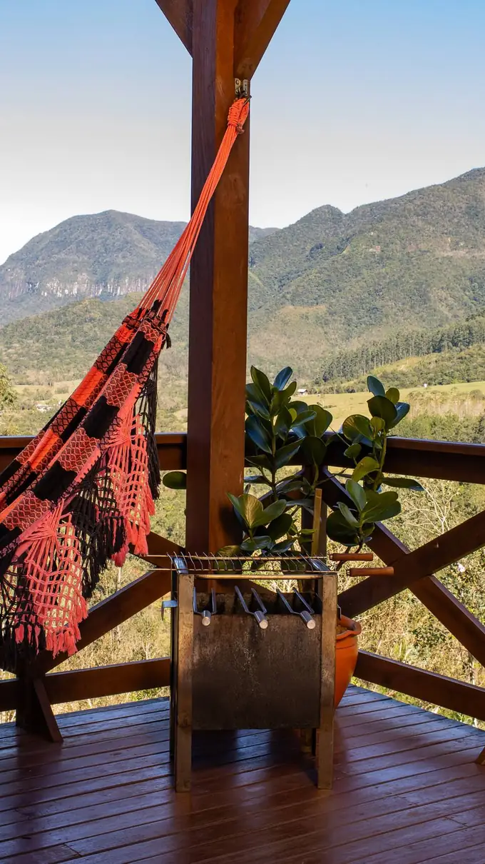 Rede na varanda de madeira, com as montanhas ao fundo