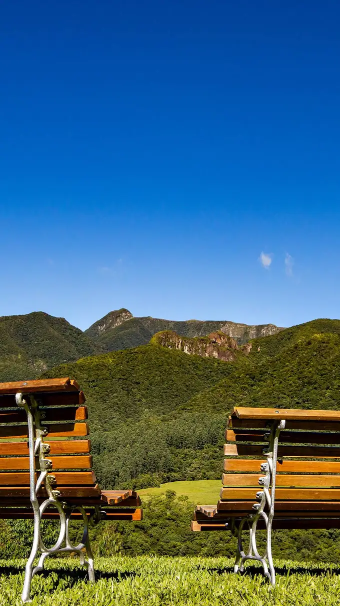 Dois bancos de madeira de frente para as montanhas